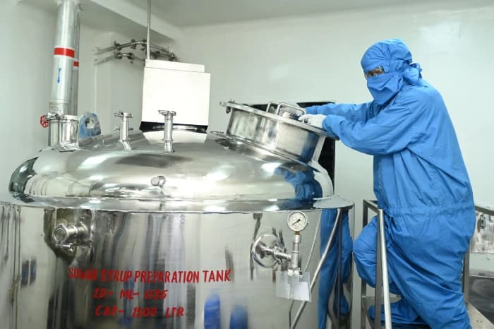 A technician working at a stainless-steel preparation tank inside the Makin manufacturing plant
